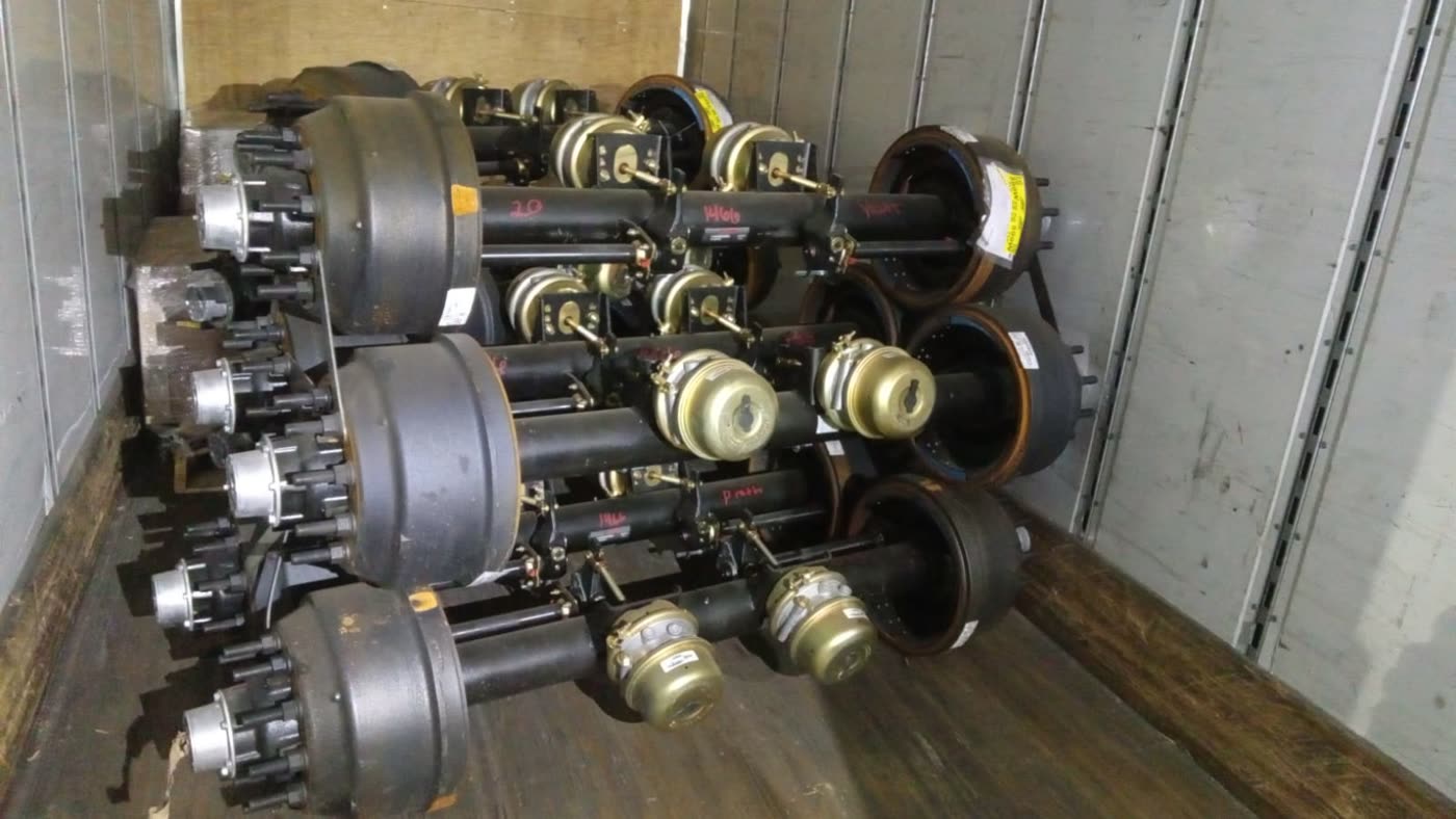 Trailer axles with brake drums and brake chambers loaded in a dry van for import into Mexico